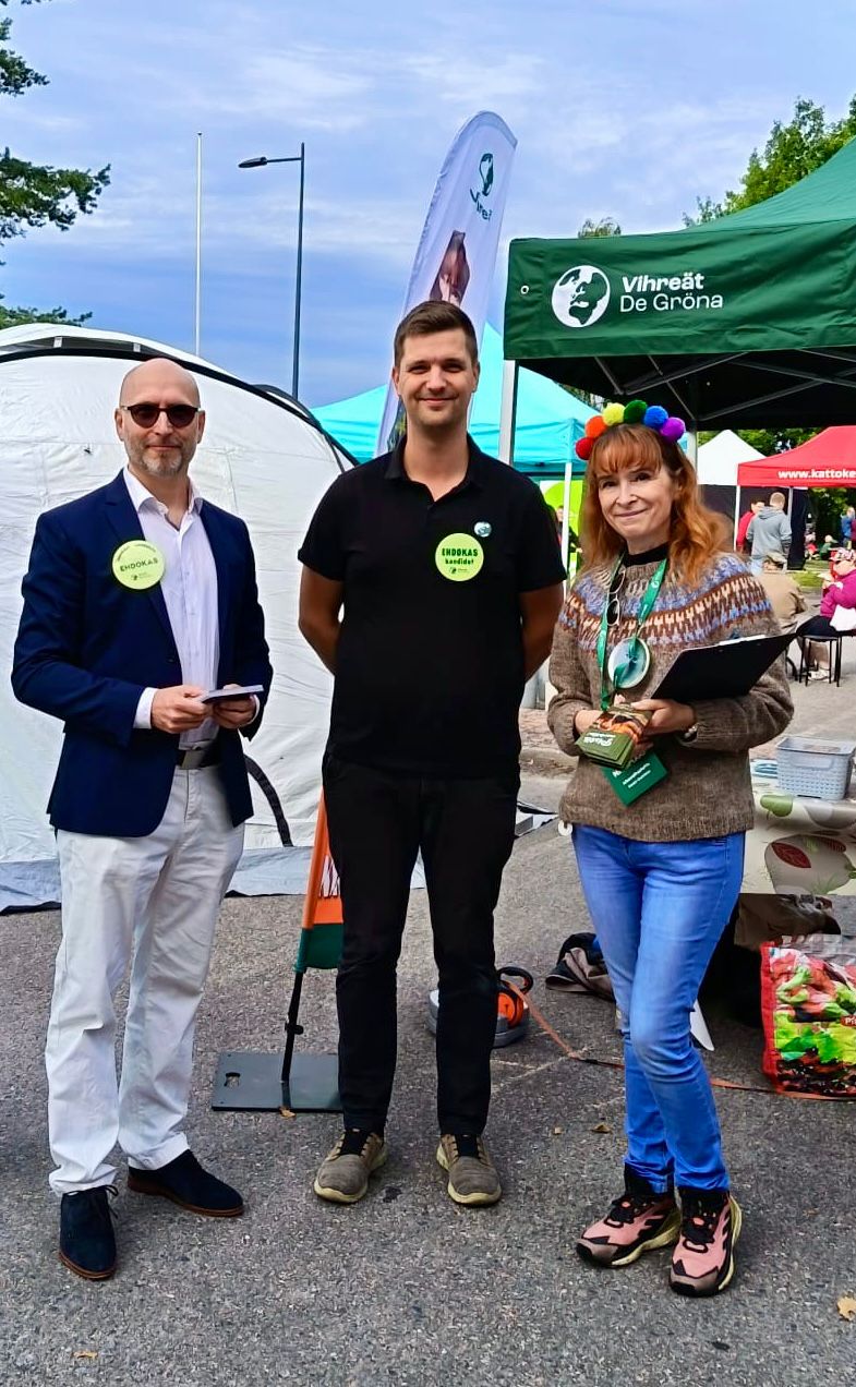 Henkilökuva. Leni ja kaksi muuta henkilöä Nurmijärven vihreiden teltan edustalla.